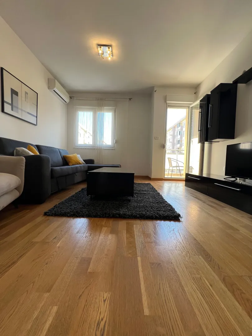 Living room with a sofa, TV, and terrace access.
