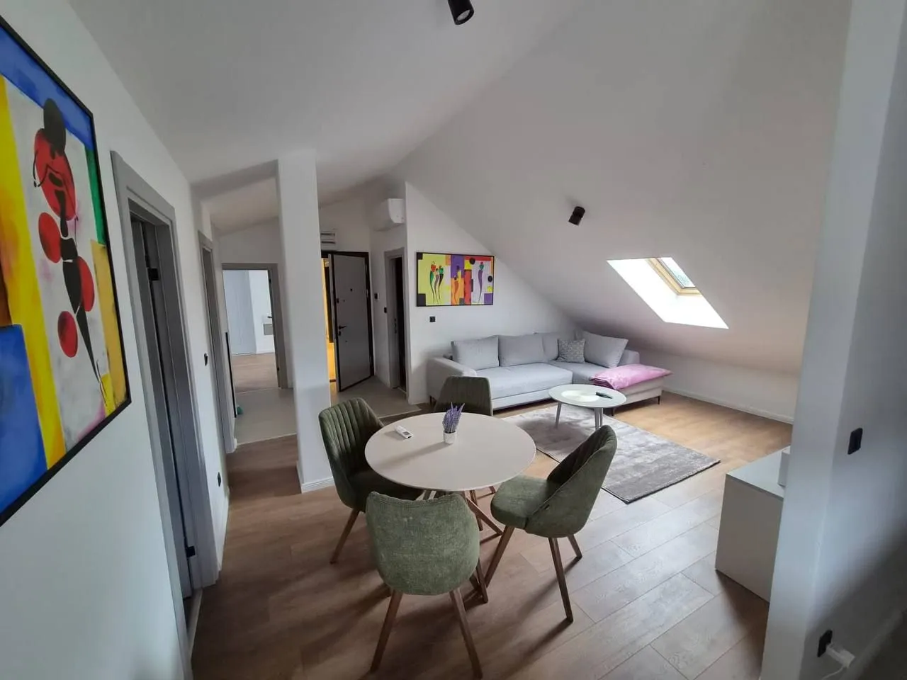 Living room with a dining area and a sloped ceiling in the attic.