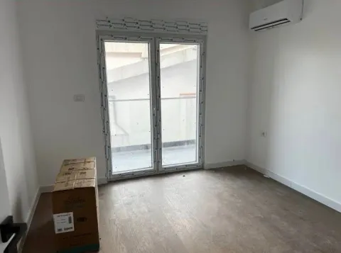 Empty room with wooden flooring, balcony doors, and an air conditioning unit. - image 3