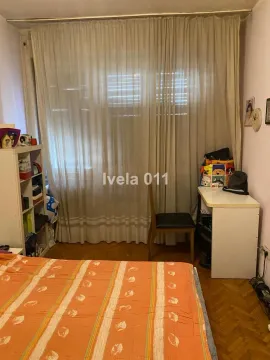Pogled na spavaću sobu sa krevetom, radnim stolom i policama. - image 3
