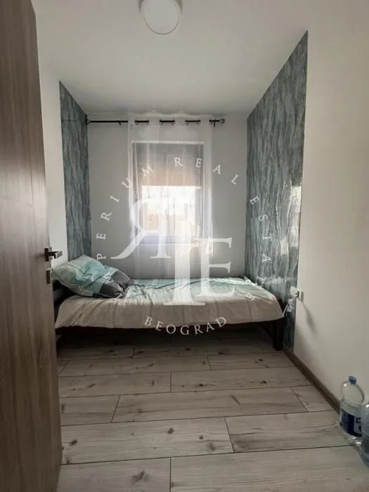 Small bedroom with a bed and a window.