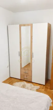 Spavaća soba sa velikim garderoberom sa ogledalom i drvenim podom. - image 7