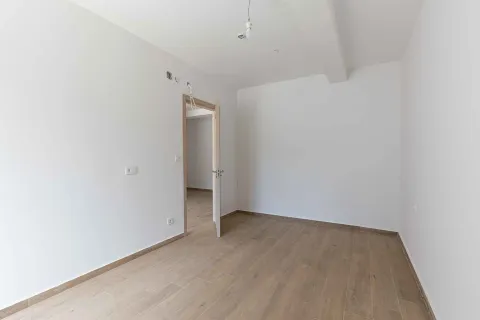 Prazna neopremljena prostorija sa bijelim zidovima i drvenim podom. - image 14