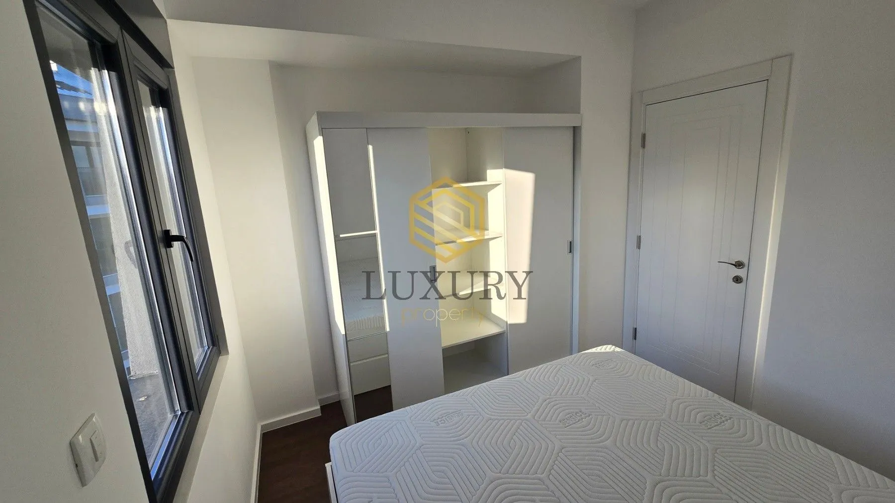 Bright bedroom with a bed and wardrobe.