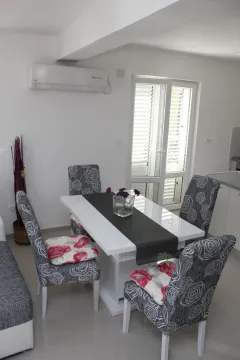 Dining area with a white table and patterned chairs. - image 4