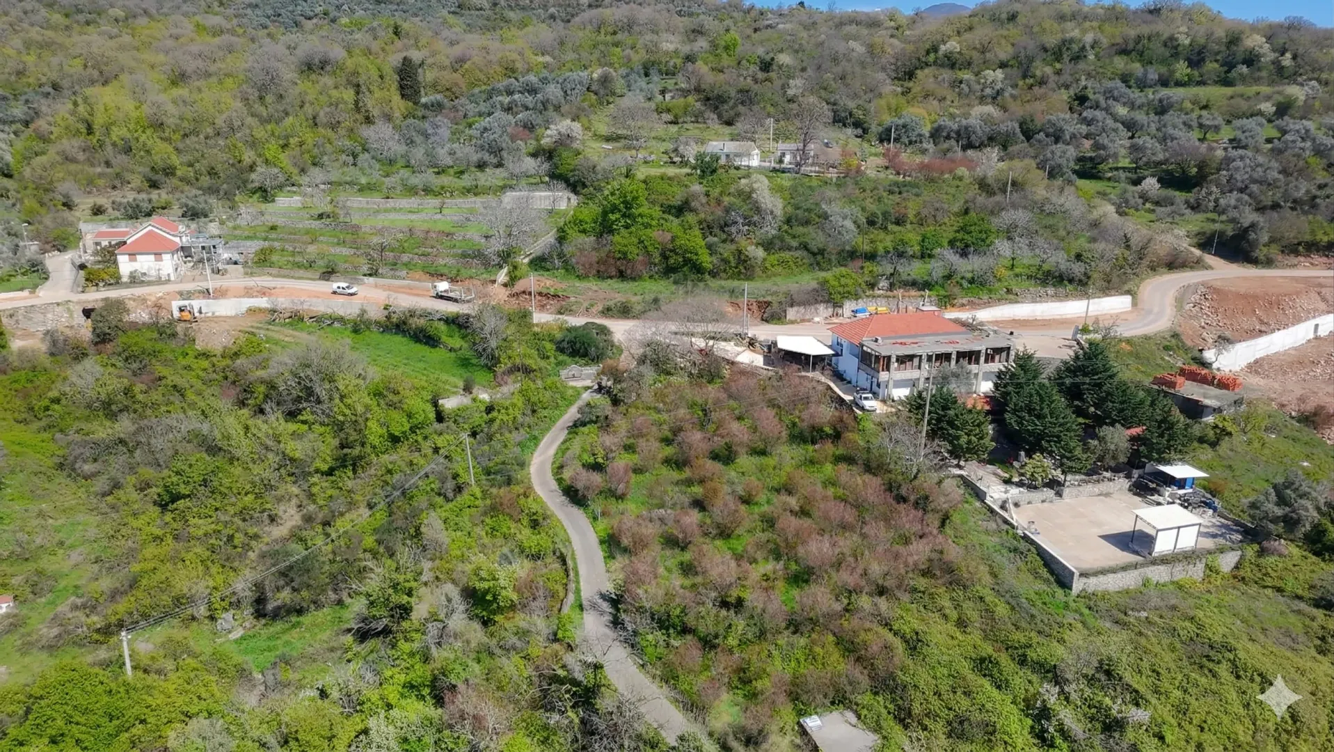 Pogled iz vazduha na imanje i okolni krajolik sa zelenilom.