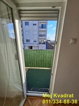 View through the balcony door to the terrace and surrounding buildings. - image 16