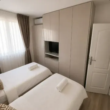 Spavaća soba sa dva singl kreveta, velikim plakarom i televizorom. - image 7