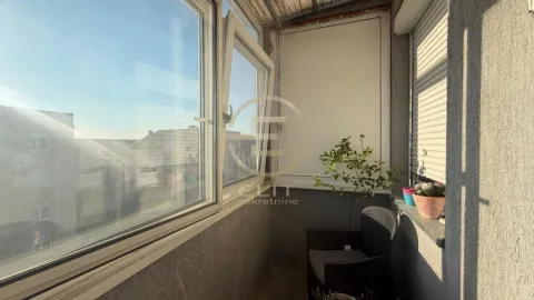 Zastakljeni balkon sa stolicom i saksijama sa biljkama. - image 4