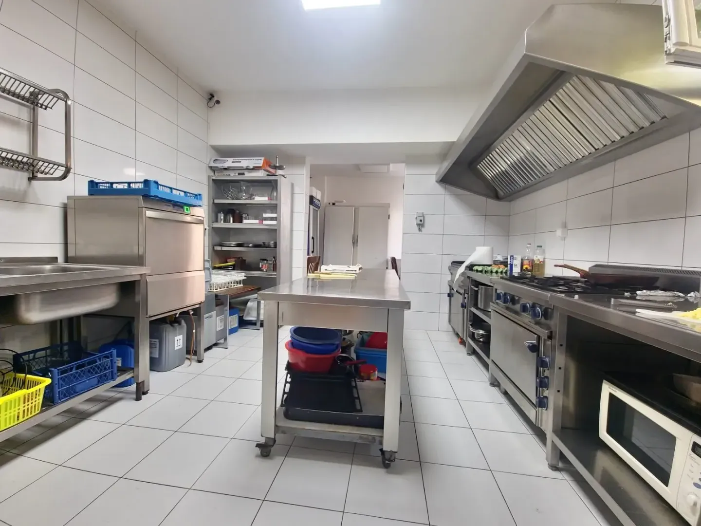 Commercial kitchen with professional stainless steel equipment.