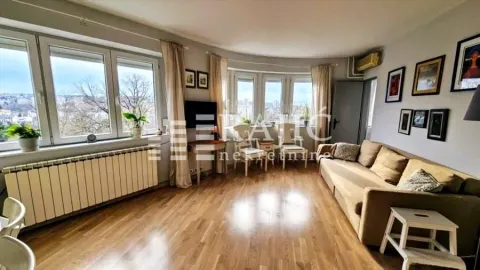 Spacious living room with a sofa and large windows letting in plenty of natural light. - image 3