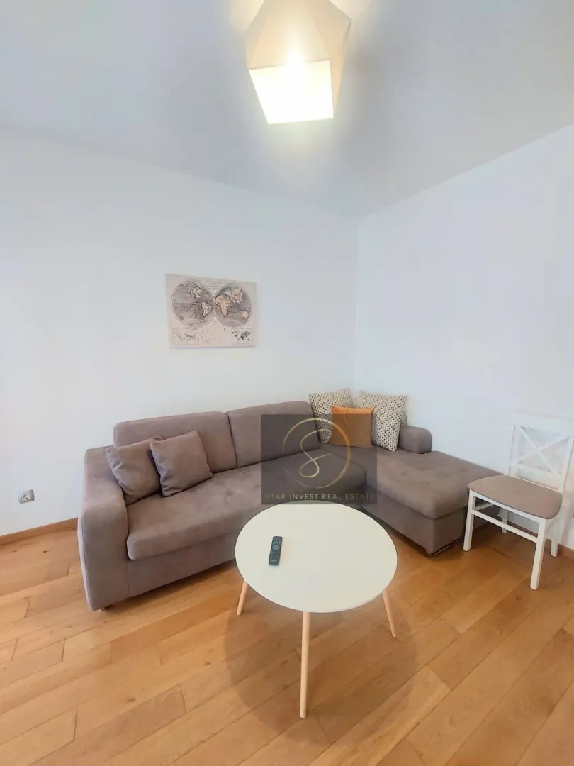 Living room with a corner sofa, coffee table, and hardwood flooring.