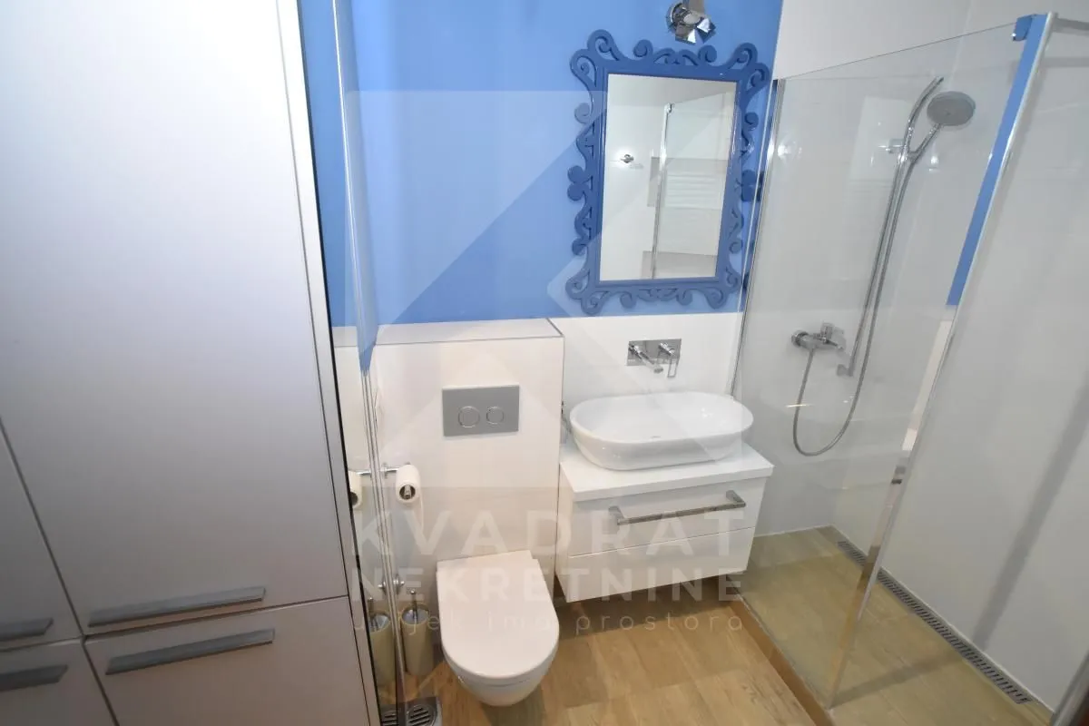 Moderne kupatilo sa tuš kabinom, umivaonikom i wc šoljom.