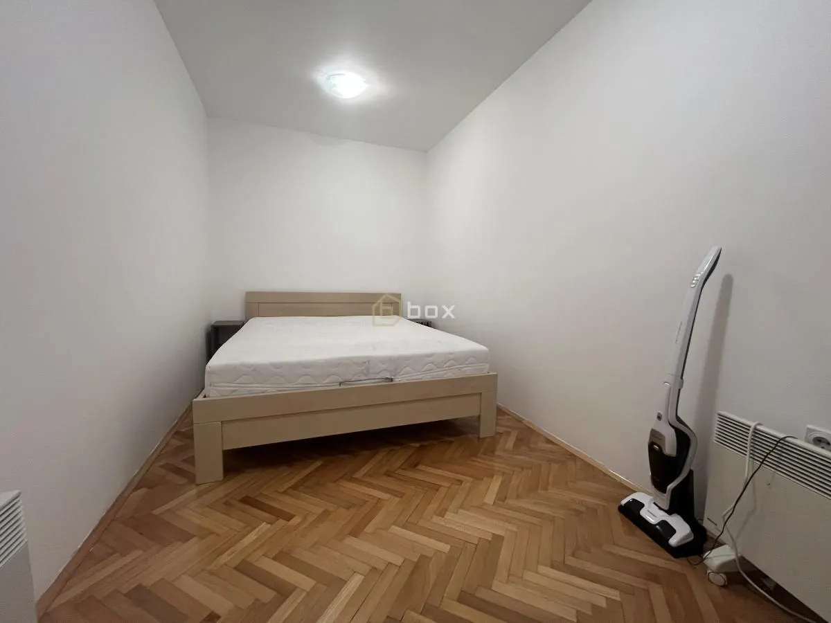 Bedroom with a double bed and parquet flooring.