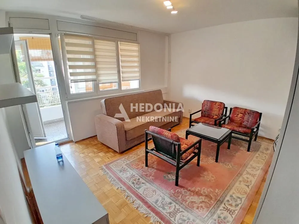Dnevna soba sa garniturom za sedenje i izlazom na terasu.