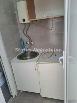 Smaller kitchen with a sink, water heater, and cabinets. - image 9