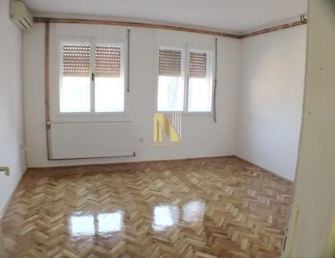 Empty room with parquet flooring and white walls.