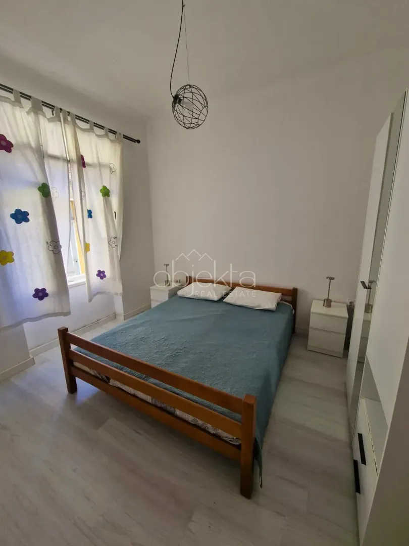 Spavaća soba sa bračnim krevetom, noćnim stočićima i garderoberom.