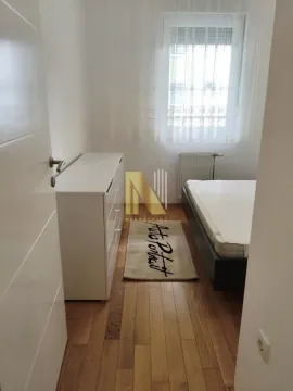 Manja spavaća soba sa krevetom, komodom i drvenim podom. - image 4