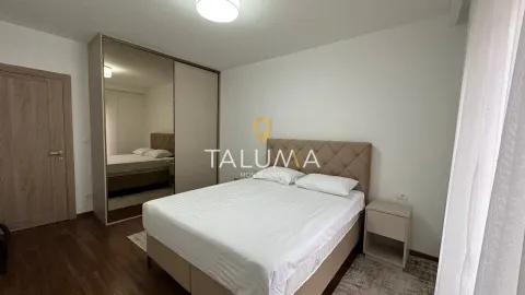 Furnished bedroom with a double bed, bedside table, and a large built-in wardrobe with a mirror. - image 4