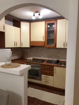 Smaller kitchen with wooden cabinets and a breakfast bar. - image 9