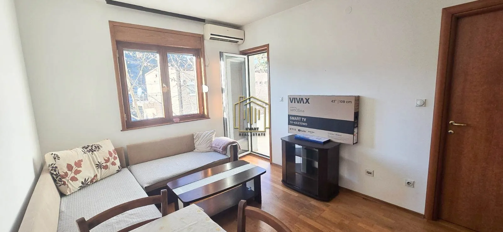 Living room with a sofa, TV, and access to the terrace.