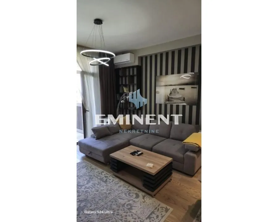 Living room with a sectional sofa, coffee table, and modern lighting.