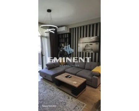 Living room with a sectional sofa, coffee table, and modern lighting. - image 3