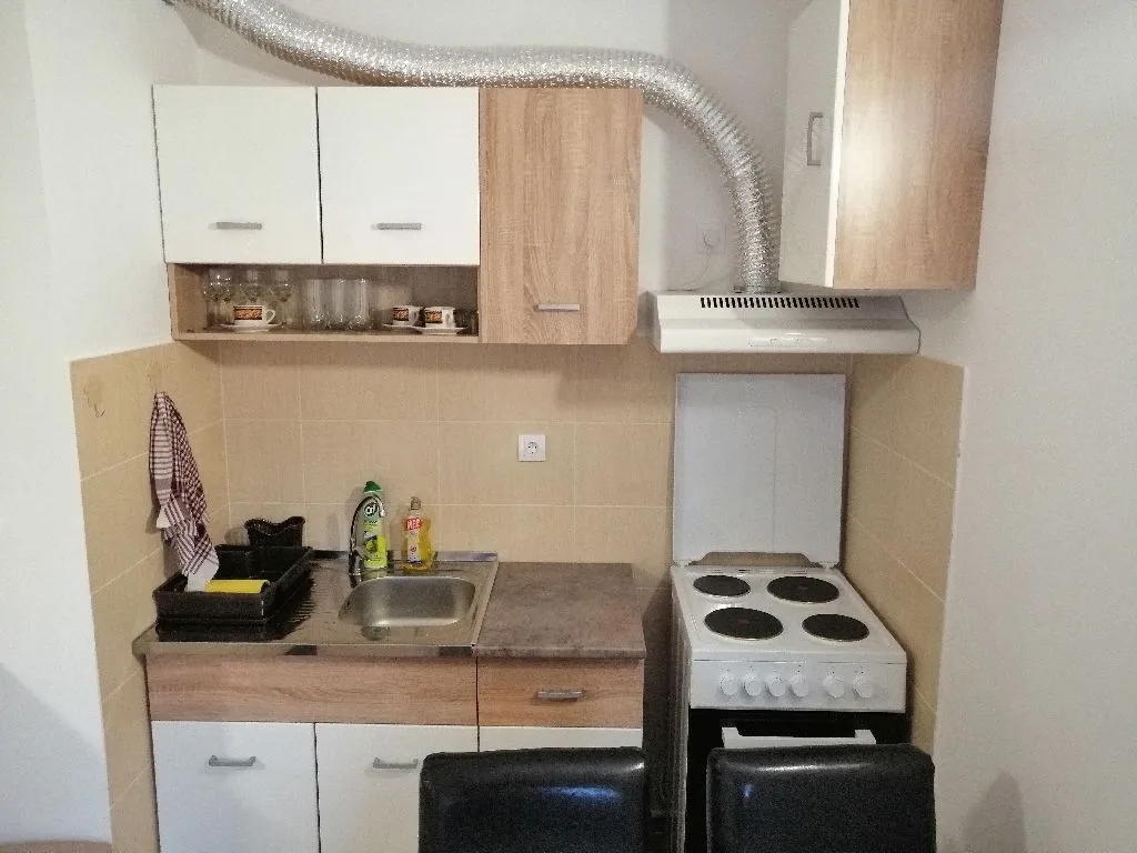 Manja kuhinja sa elementima, šporetom i sudoperom.