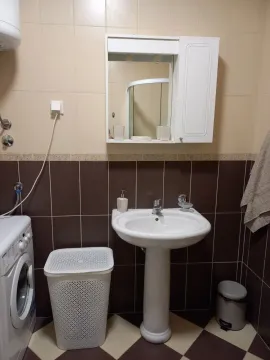 Smaller bathroom with a sink, mirror, toilet and washing machine. - image 3