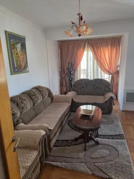 Living room with a seating set, coffee table, and a window with curtains. - image 4
