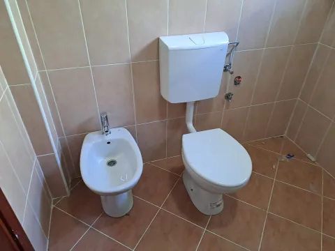 Kupatilo sa wc šoljom i bideom u bež pločicama. - image 14