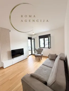 Furnished living room with a sofa and television. - image 2