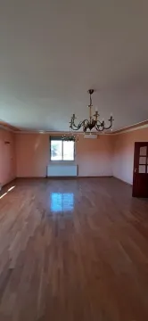 Empty spacious living room with wooden flooring and chandeliers. - image 3