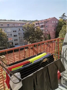 Balkon sa stalkom za sušenje veša i pogledom na okolne zgrade i naselje. - image 5