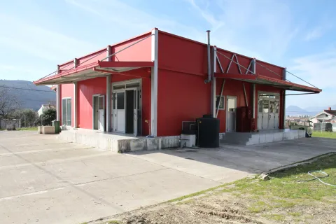 Exterior of a modern red prefabricated building with a concrete plateau. - image 3