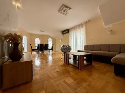 Spacious living room with a sofa, coffee table, and dining area in the background. - image 4