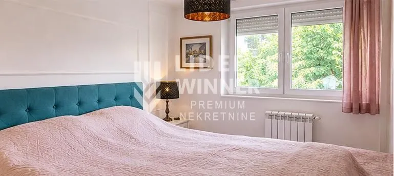 Furnished bedroom with a double bed and a window.
