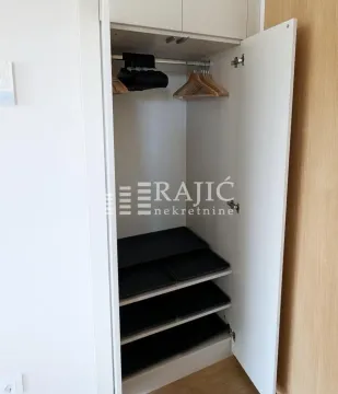 Open white wardrobe with shelves and hangers. - image 13