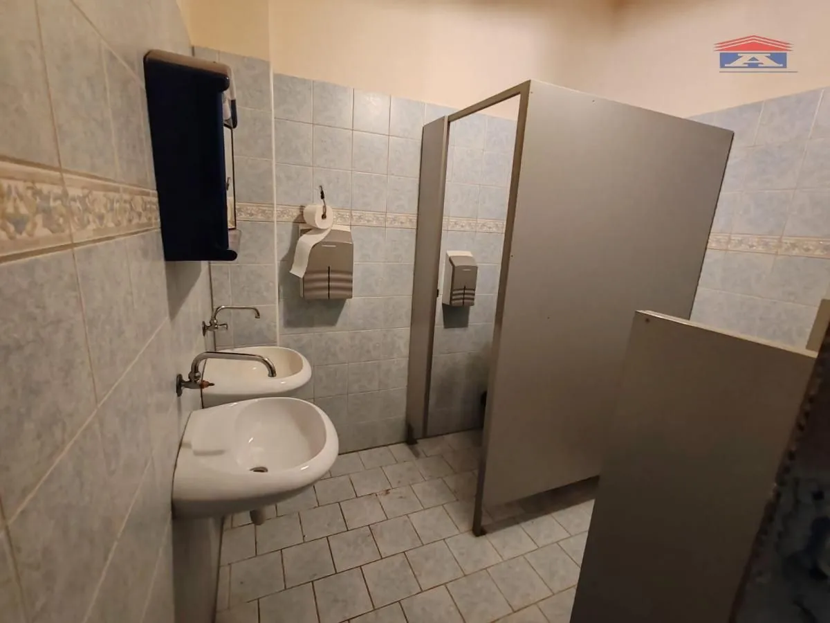 View of the bathroom with a sink and partition cabins.