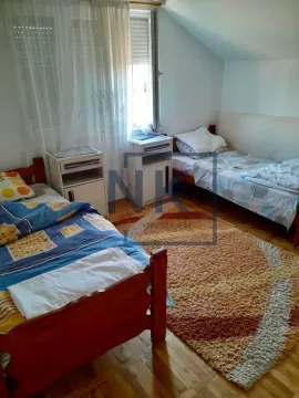 Spavaća soba sa dva kreveta, noćnim ormarićem i prozorom. - image 4