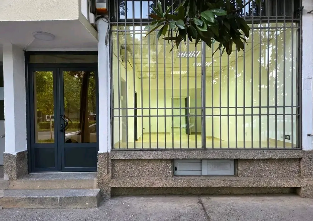 View of the entrance and exterior of the commercial space with security bars on the windows.