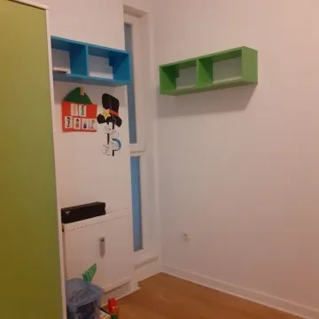 Children's bedroom with white walls, wooden floor, and wall shelves. - image 6