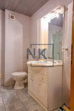 Bathroom equipped with a vanity unit with a sink, mirror, and toilet. - image 7