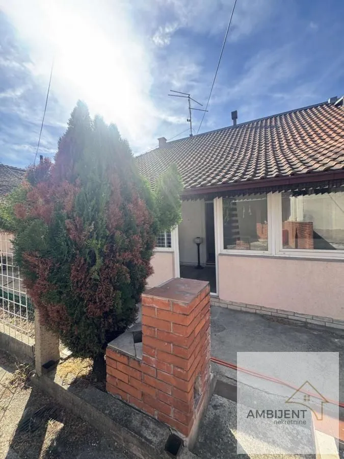 Pogled na dvorište i fasadu kuće sa uređenim ulazom.