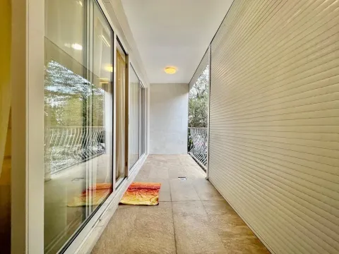A long and bright balcony with tiled flooring and sliding glass doors. - image 10
