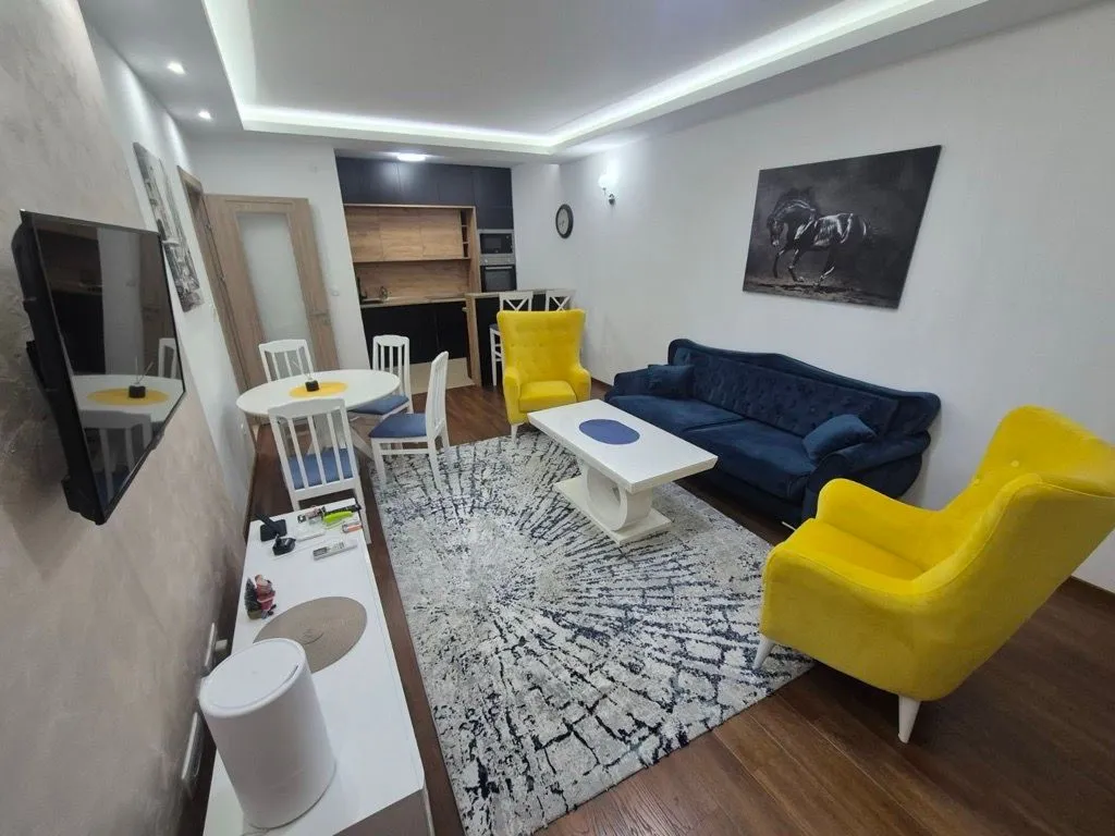 Spacious living room with sofa set, dining area, and kitchen in the background.