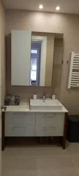 Modern bathroom with a sink, mirror, and cabinet. - image 8