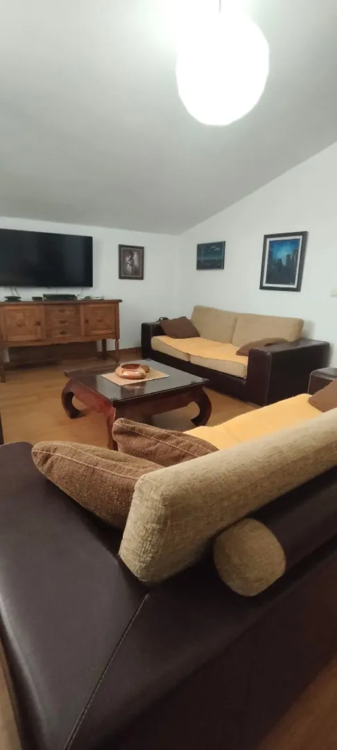 Living room furnished with a sofa set, coffee table, and TV console.