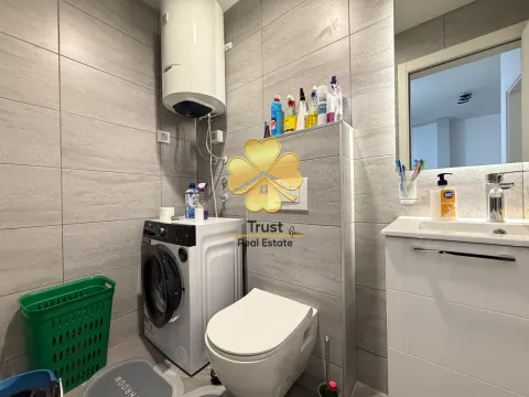 Modern bathroom with a washing machine, water heater, and sink. - image 10